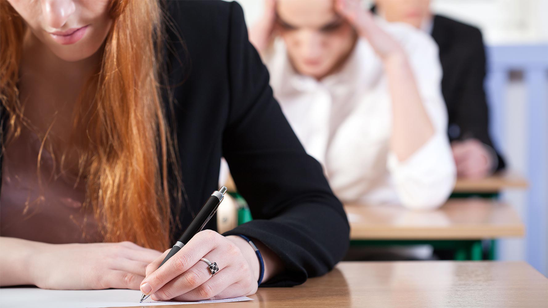 Detailfoto auf Schülerin, die ein Test schreibt (PISA-Bericht Schweiz, Bildungsmonitoring)