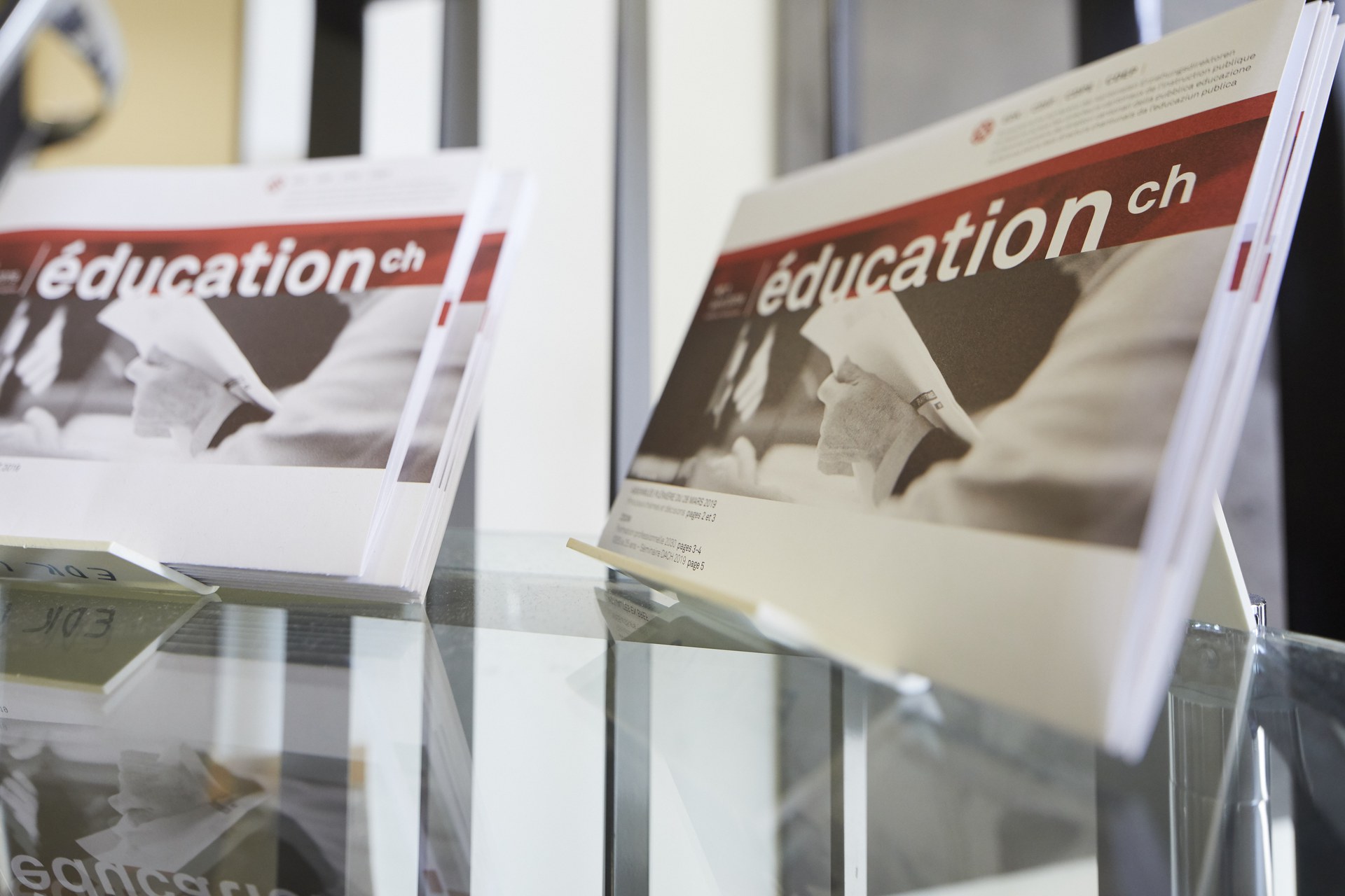 The EDK's printed newsletter sits on a bookstand on a glass table