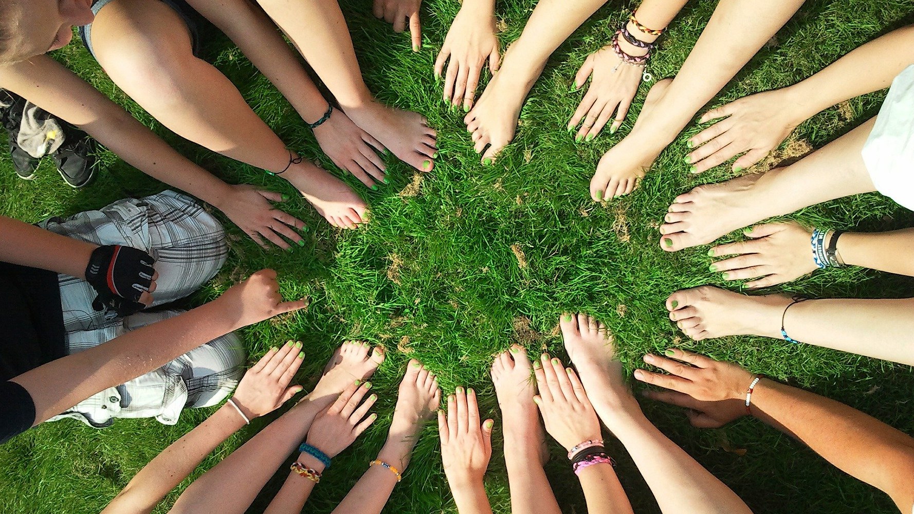 Les mains et les pieds forment un cercle dans l'herbe