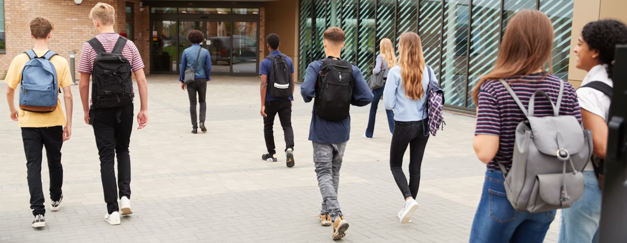 De jeunes élèves affluent vers l’entrée de l’école