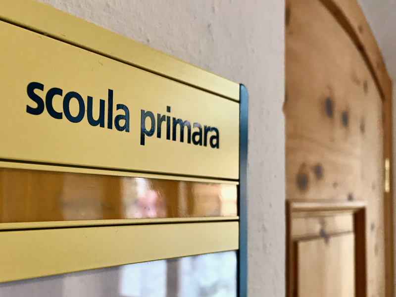 Una targa sulla porta di una scuola recita: "scoula primara"